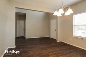 Tomball house for rent - an empty living room with wood floors and a white door