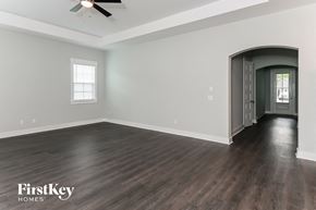 Summerville house for rent - A spacious room with wooden floors and a ceiling fan.