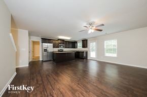 Lexington house for rent - an empty living room and kitchen with wood flooring and a ceiling fan