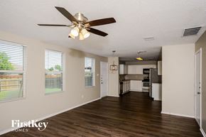 Anna house for rent - A spacious living room with a ceiling fan and wooden floors.