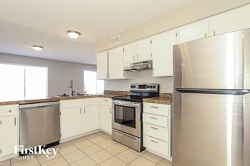 Tempe house for rent - a kitchen with stainless steel appliances and white cabinets