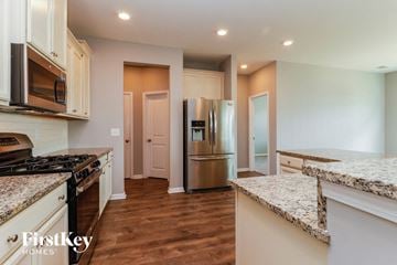 Summerville house for rent - A kitchen with a granite counter top and wooden floors.