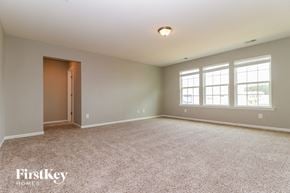 Summerville house for rent - A spacious room with a carpeted floor and a door leading to another room.