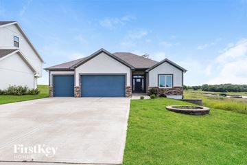 Platte City house for rent - a house with a driveway and a blue garage door