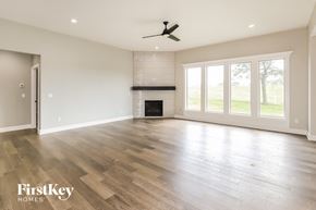 Platte City house for rent - an empty living room with a fireplace and wooden floors