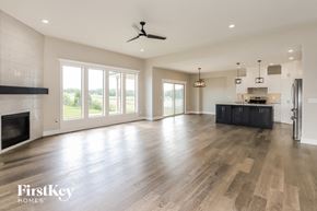 Platte City house for rent - an empty living room with a fireplace and a kitchen