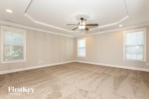 Winston Salem house for rent - A spacious room with a ceiling fan and carpeted floor.