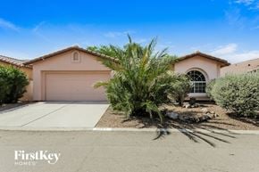 Tucson house for rent - A house with a brown roof and a white garage door is for sale.