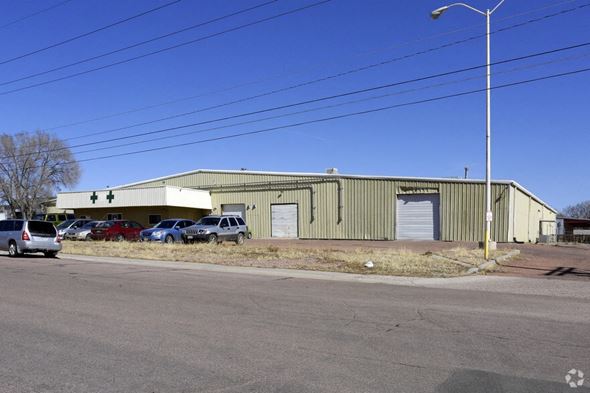 Colorado Springs apartment for rent - A large industrial building with a parking lot in front.