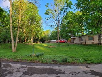 Carmel house for rent - a yard with a house and a red car in the background