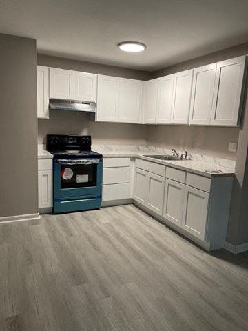 Collingswood apartment for rent - a kitchen with white cabinets and a stove and a sink