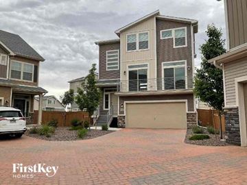 Commerce City house for rent - a house with a driveway and a car garage