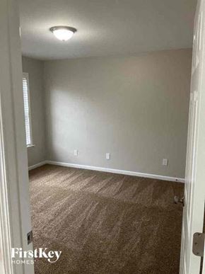 Charlotte house for rent - A carpeted room with a door on the left and a light on the ceiling.