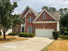 Charlotte house for rent - A brick house with a garage door is for sale.