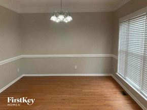 Charlotte house for rent - A room with wooden floors and a chandelier hanging from the ceiling.