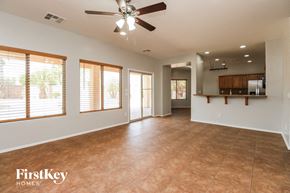 San Tan Valley house for rent - an empty living room with a ceiling fan and a kitchen