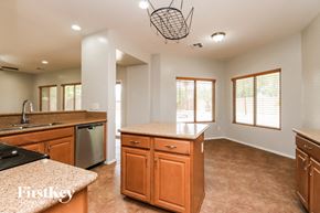 San Tan Valley house for rent - a kitchen with wooden cabinets and granite counter tops and a sink