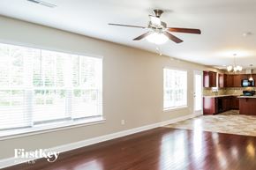 Thomasville house for rent - A spacious room with a ceiling fan and a kitchen area in the background.