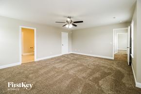 Thomasville house for rent - A spacious room with a carpeted floor and a ceiling fan.