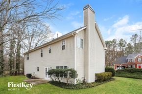 Powder Springs house for rent - A house with a white exterior and a chimney is shown.