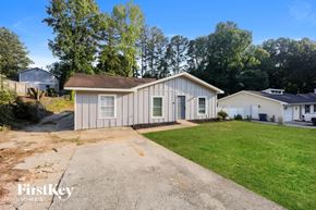 Rex house for rent - a small white house with a driveway and a grassy yard