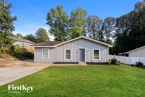 Rex house for rent - a small white house with a lawn and a driveway