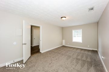 Rex house for rent - a living room with carpet and a door to a hallway