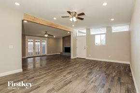 Phoenix house for rent - an empty living room with wood floors and a ceiling fan