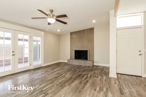 Phoenix house for rent - a living room with a fireplace and a ceiling fan