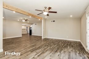 Phoenix house for rent - an empty living room with wood flooring and a ceiling fan