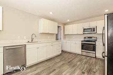 Phoenix house for rent - a kitchen with white cabinets and stainless steel appliances