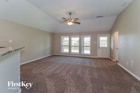 League City house for rent - an empty living room with a ceiling fan and a window