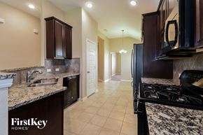 League City house for rent - a kitchen with black appliances and granite counter tops