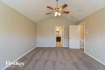League City house for rent - a spacious living room with carpet and a ceiling fan