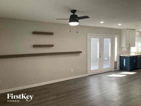 Denver house for rent - an empty living room with a ceiling fan and a door