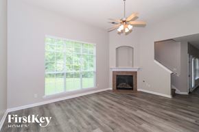 Bartlett house for rent - A room with a fireplace and a ceiling fan.