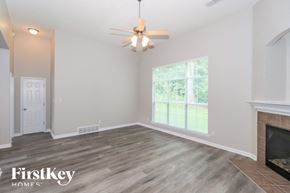 Bartlett house for rent - A room with a fireplace and a ceiling fan.