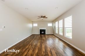 Brownsburg house for rent - A spacious room with wooden floors and a fireplace.