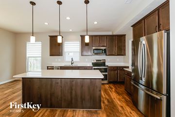Brownsburg house for rent - A modern kitchen with wooden cabinets and a stainless steel refrigerator.