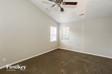 Charlotte house for rent - a living room with carpet and a ceiling fan