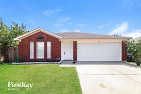 Fort Worth house for rent - a brick house with a white garage door and a lawn
