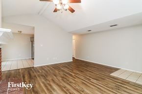 Fort Worth house for rent - the living room and dining room with wood flooring and a ceiling fan