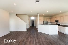 Mont Belvieu house for rent - an open kitchen and living room with white cabinets and wood flooring