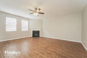 Matthews house for rent - A spacious room with a fireplace and a ceiling fan.