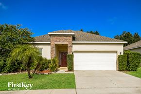 Haines City house for rent - a home with a white garage door and a palm tree