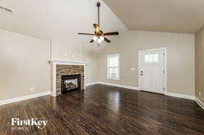 Kernersville house for rent - A spacious room with a fireplace and a ceiling fan.