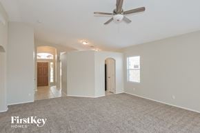 Oro Valley house for rent - the living room and entryway of an empty house with a ceiling fan