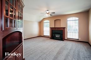 Edmond house for rent - an empty living room with a fireplace and a cabinet