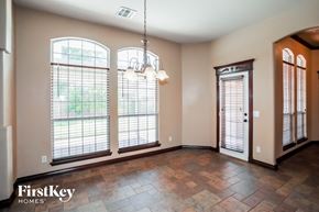 Edmond house for rent - an empty dining room with three large windows and a chandelier