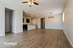 Surprise house for rent - an empty living room and kitchen with a ceiling fan
